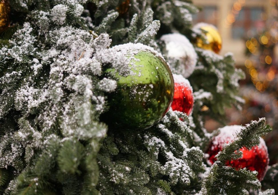 Detaljbilde av julekuler på juletre utendørs